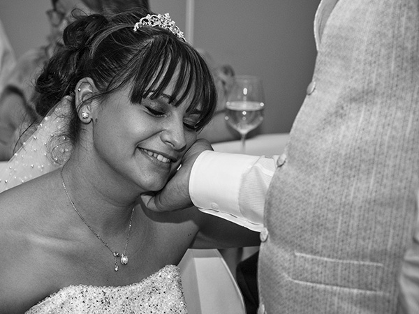 Foto: Wilhelm Watschka Fotografie. Der Bräutigam streicht bei der Hochzeit seiner Gattin über die Wange und diese genießt den Moment.