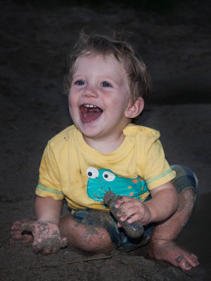 Ein Kind ist total schmutzig und lacht, weil es die Mutter überhaupt nicht lustig findet. Das Foto wurde gemacht von Wilhelm Watschka.