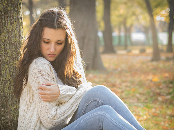 Foto: Wilhelm Watschka Fotografie. Verträumtes Portrait Foto einer Frau die sich an einem Baum lehnt und die Sonne genießt , Aufgenommen in Wien um Herbst