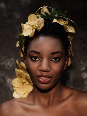 Foto: Wilhelm Watschka Fotografie I Portrait einer Frau mit gelben Blumen in den Haaren.